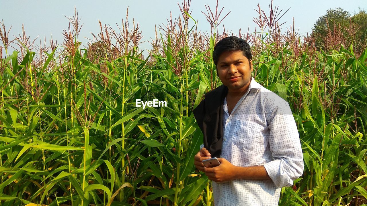 YOUNG MAN STANDING ON FARM