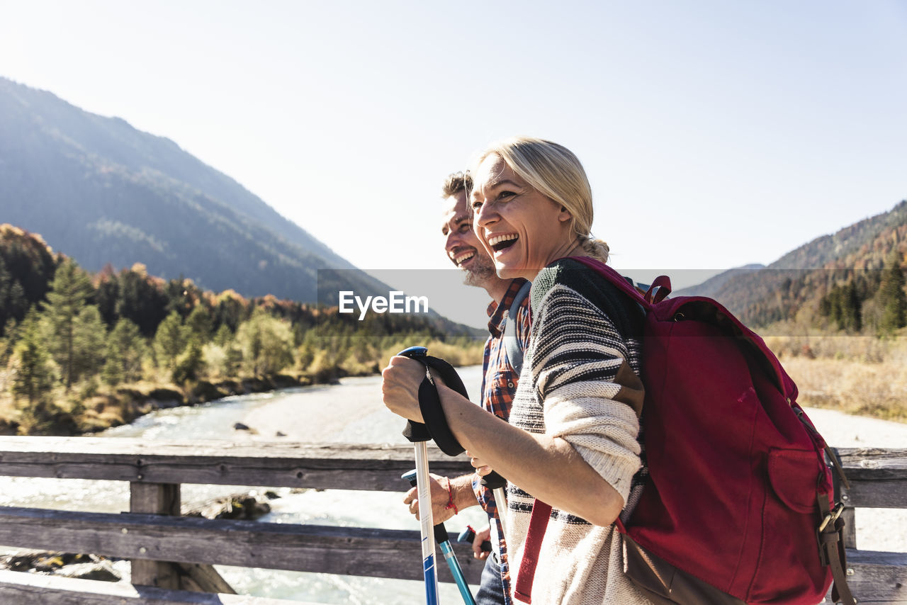 Austria, alps, happy couple on a hiking trip crossing a bridge