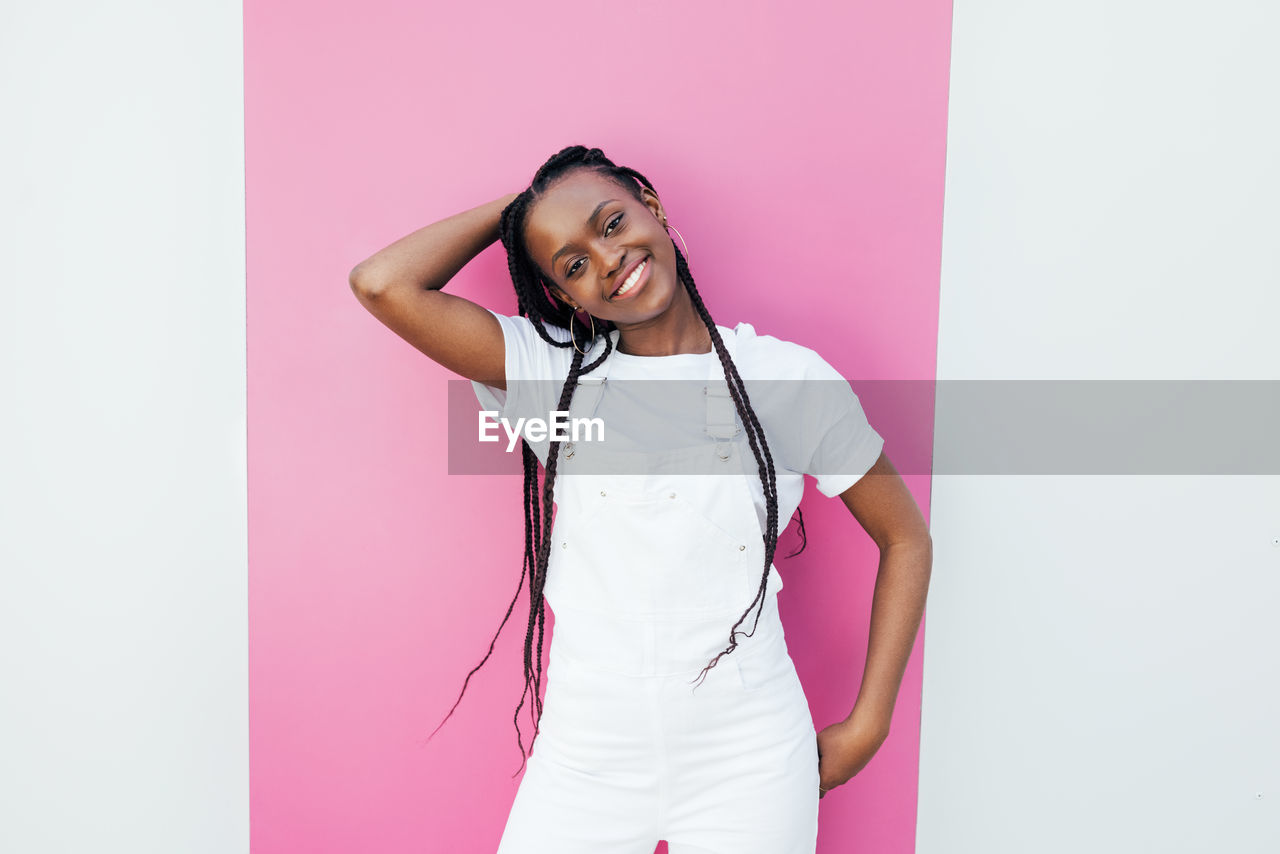 Smiling woman standing against colored background