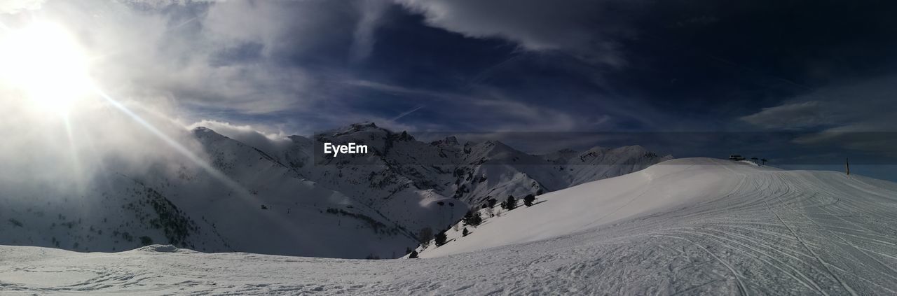 PANORAMIC VIEW OF SNOWCAPPED MOUNTAINS AGAINST SKY