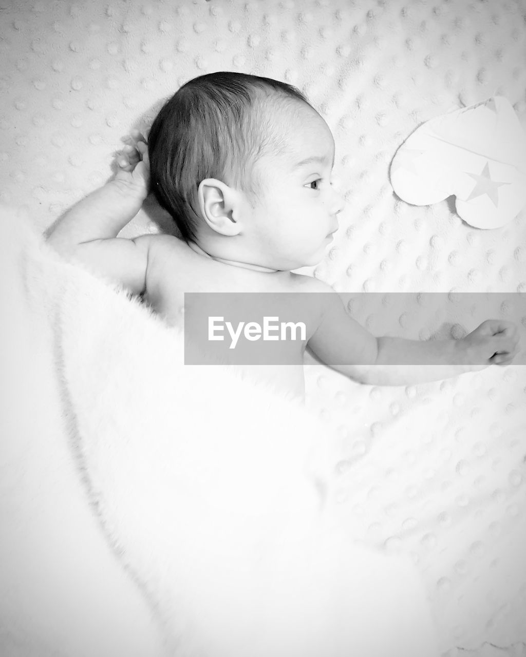 Directly above shot of cute baby girl lying on crib