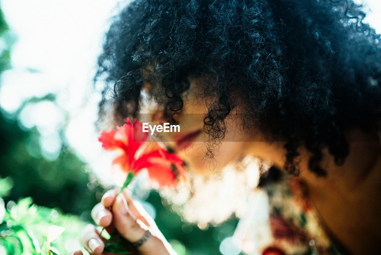 Close-up portrait of woman holding flowering plant