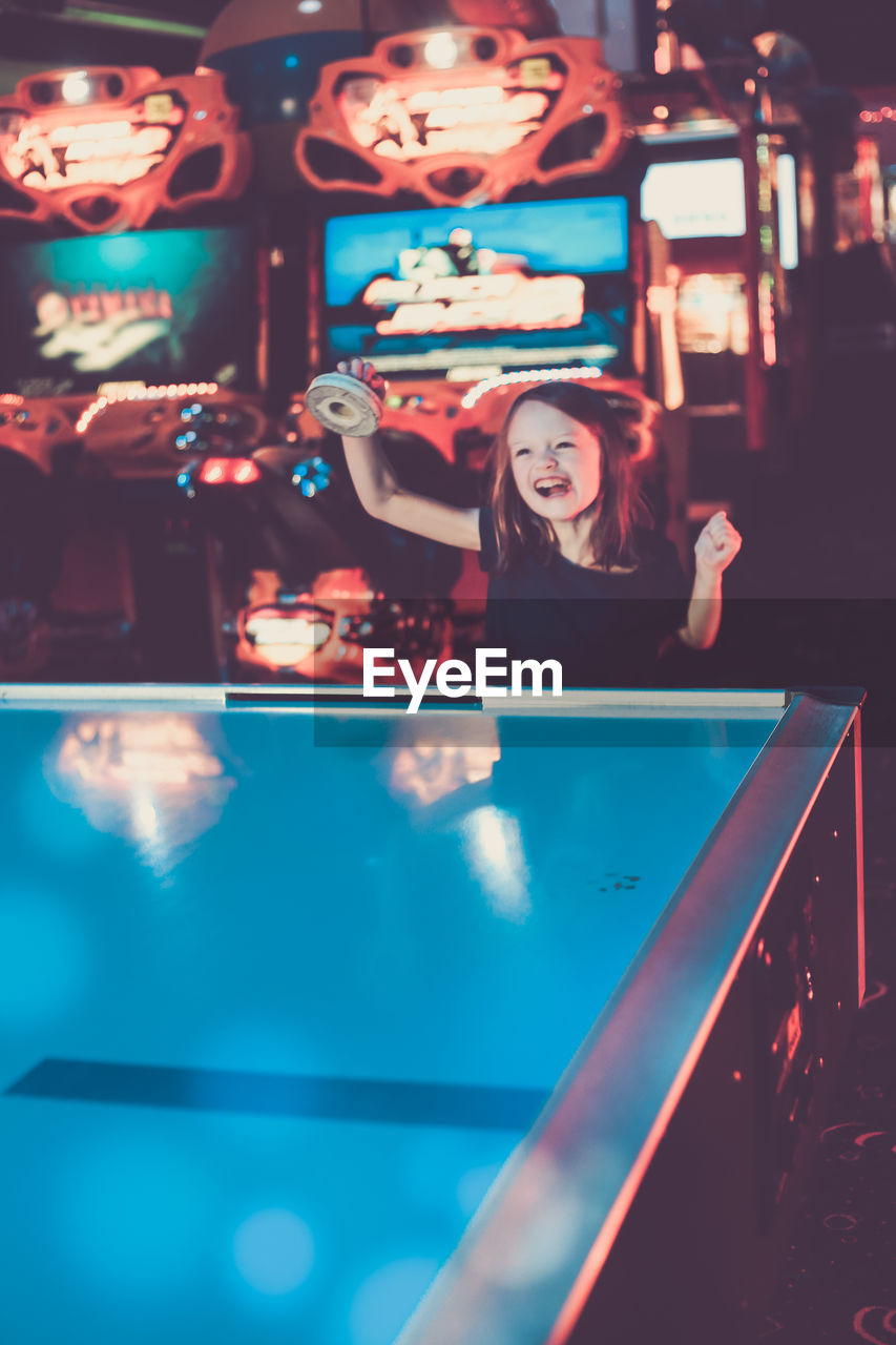 Happy girl playing at table in illuminated room