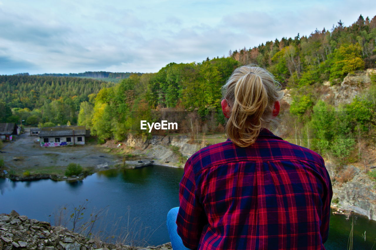 Woman sitting against lake