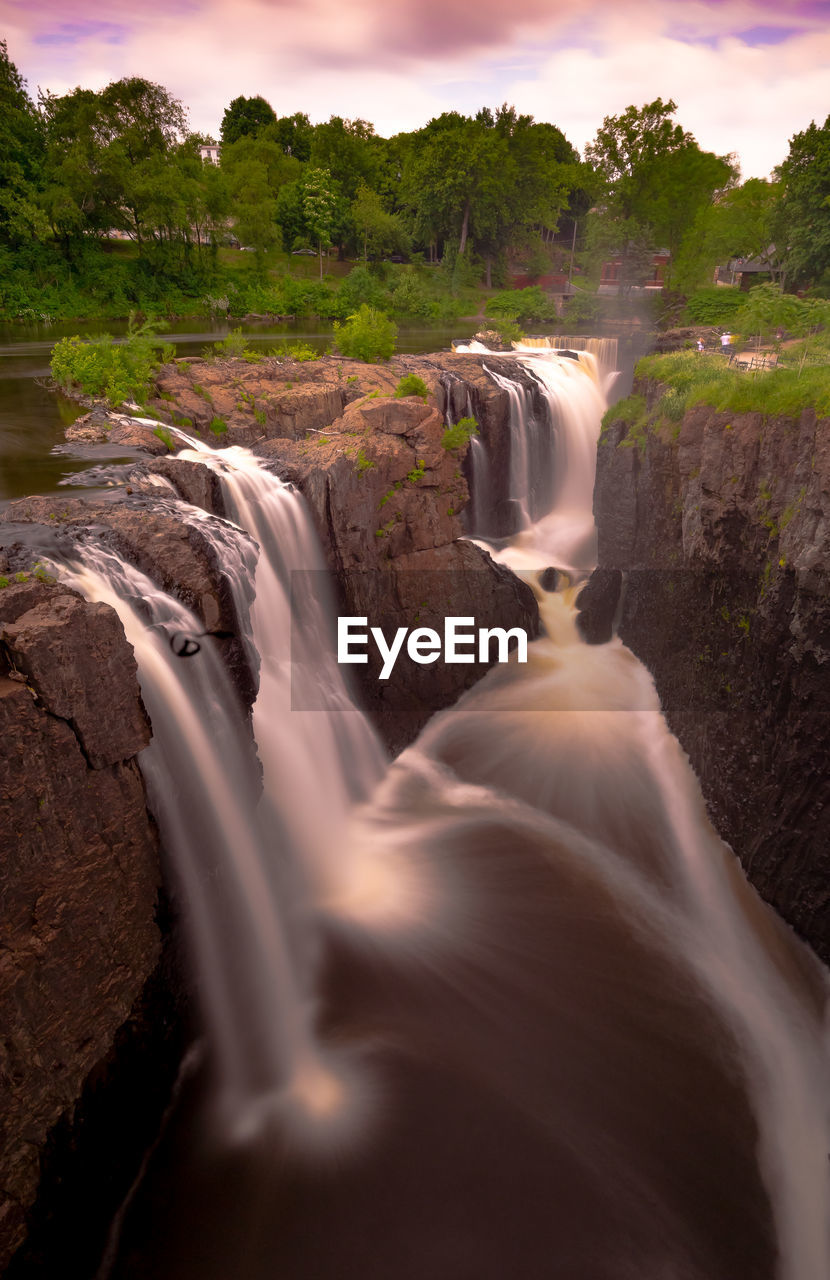 SCENIC VIEW OF WATERFALL AGAINST ROCKS