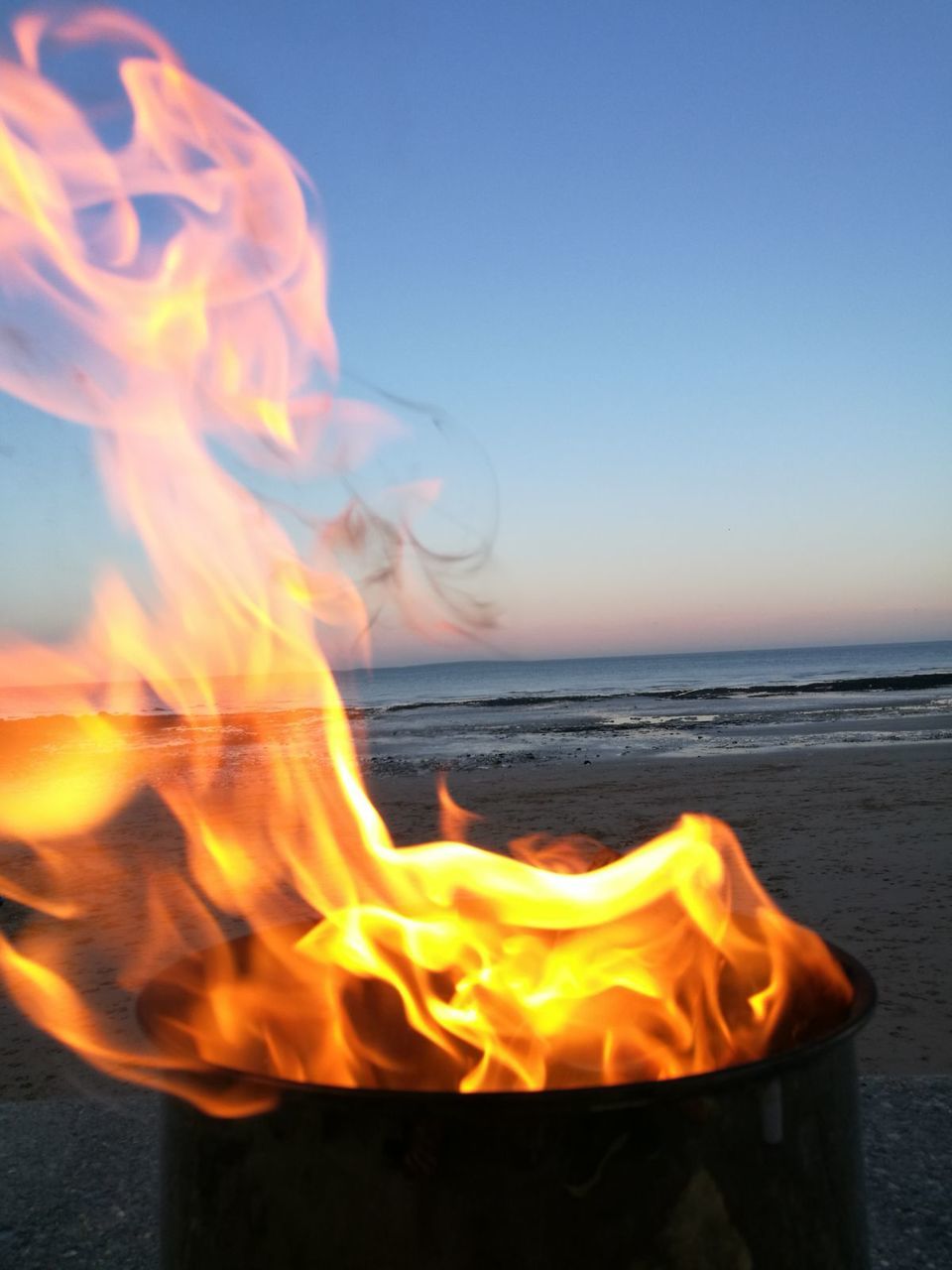 CLOSE-UP OF BONFIRE ON BEACH AGAINST SKY AT NIGHT