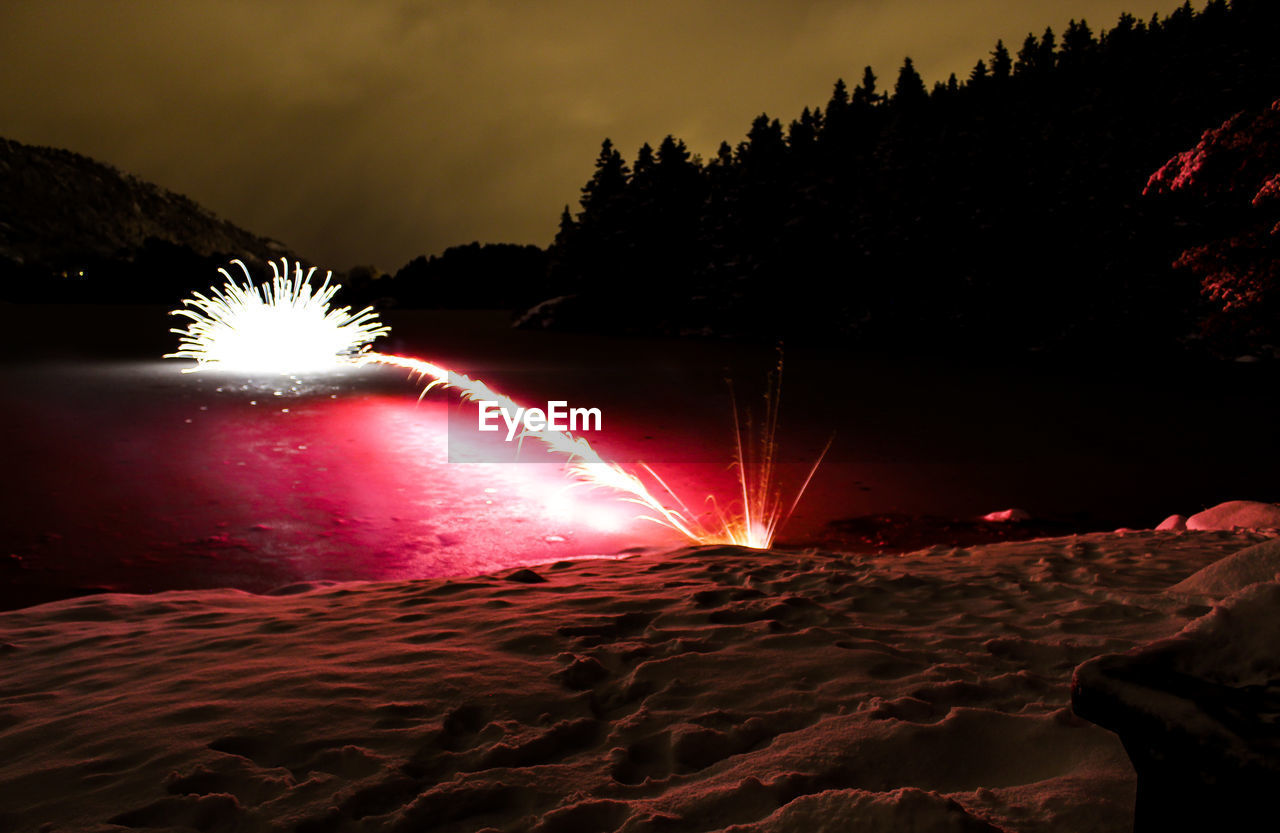 CLOSE-UP OF ILLUMINATED WATER AT NIGHT