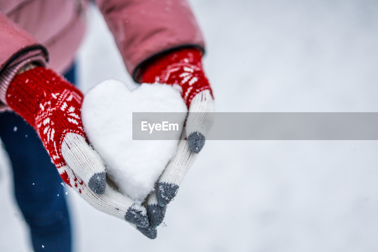 Close-up of hand holding heart shape in winter