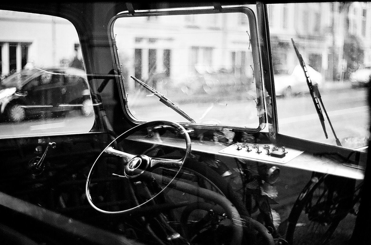 Double exposure of car interior and bicycles on street