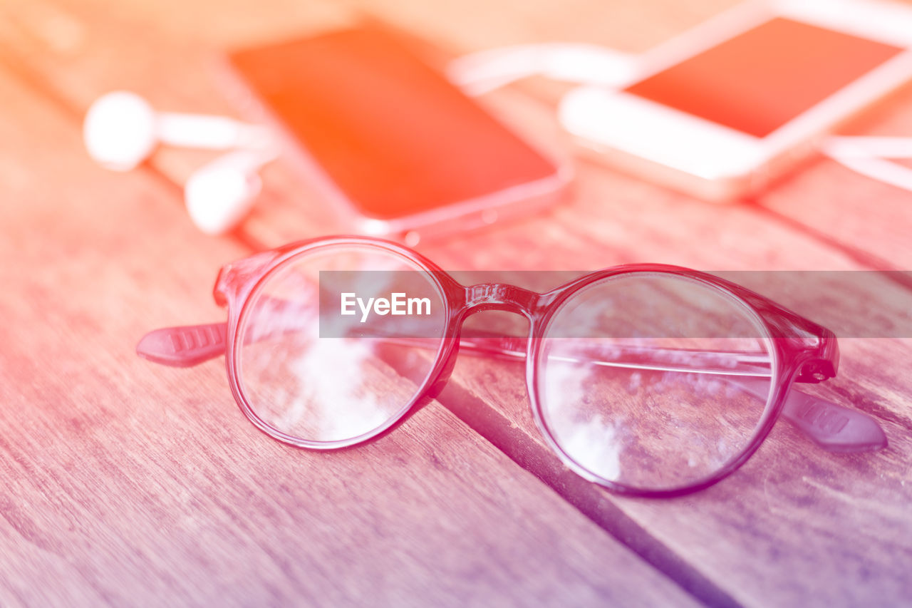 HIGH ANGLE VIEW OF SUNGLASSES AND EYEGLASSES ON TABLE