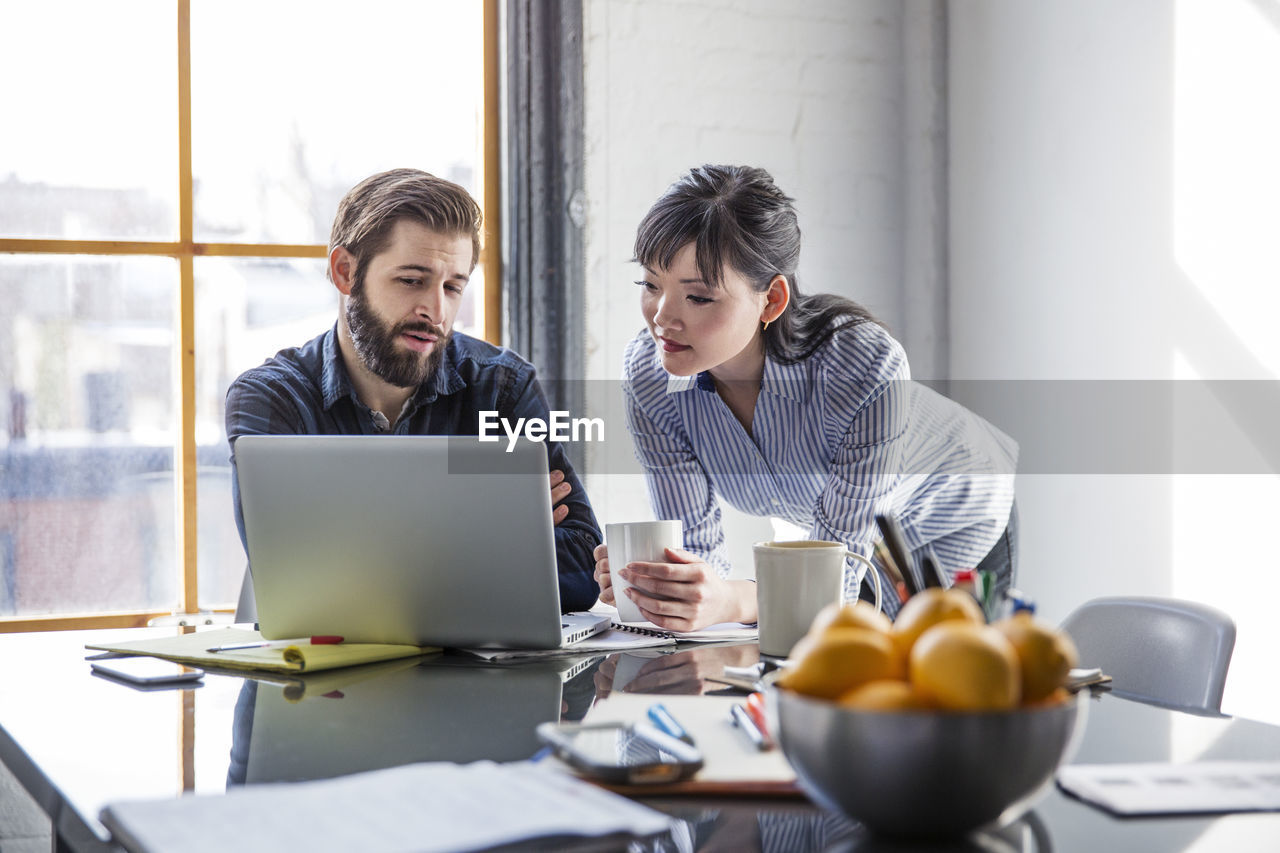 Business people using laptop at creative office