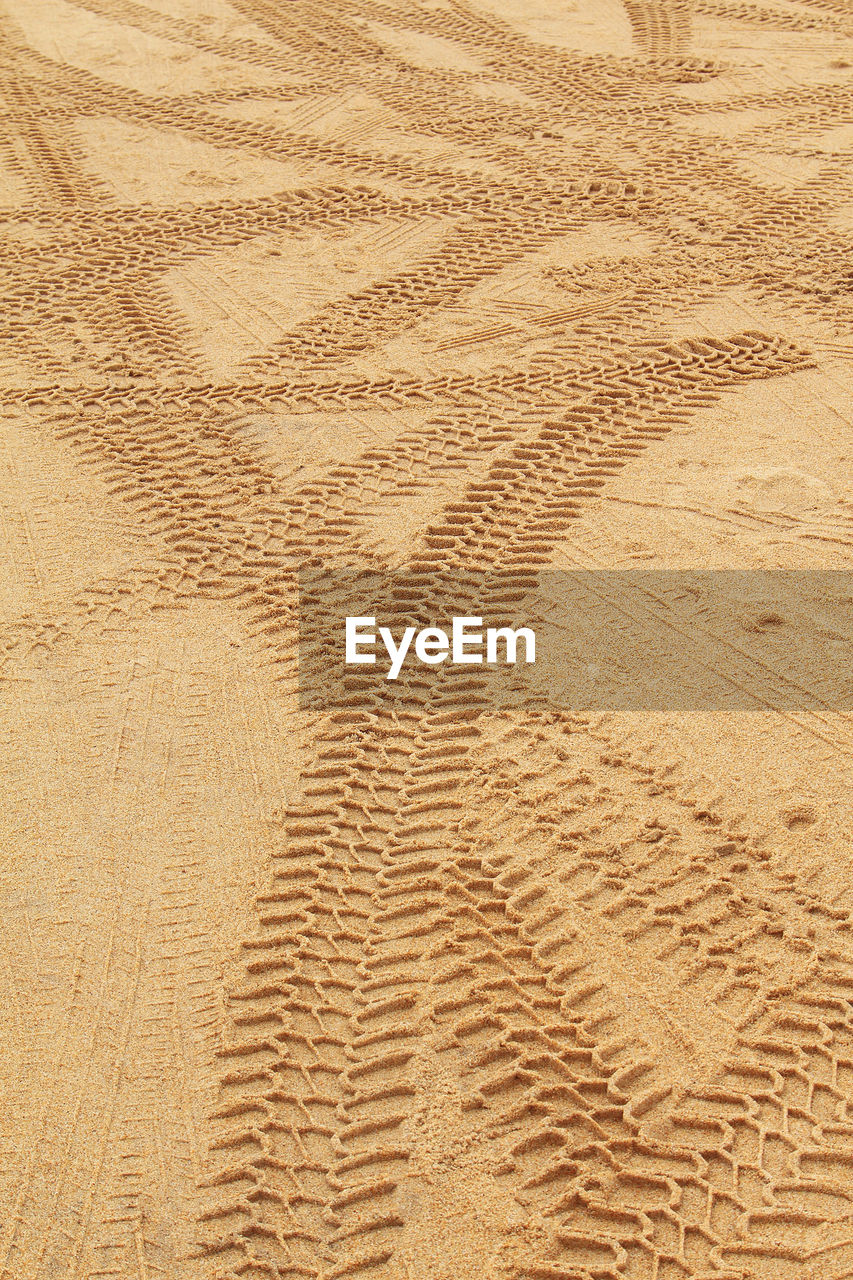 HIGH ANGLE VIEW OF TIRE TRACKS ON DESERT