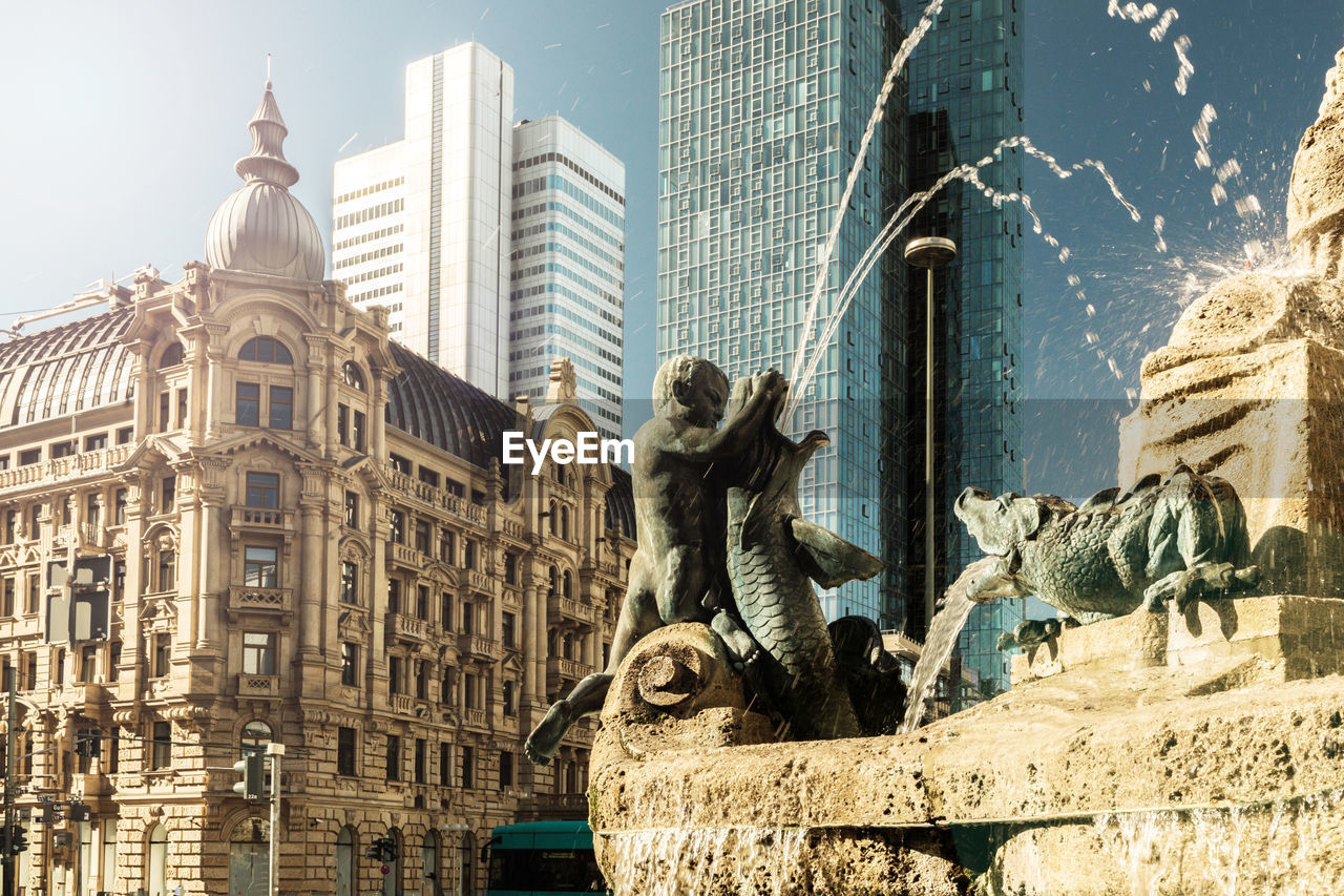 Low angle view of statue against buildings in city