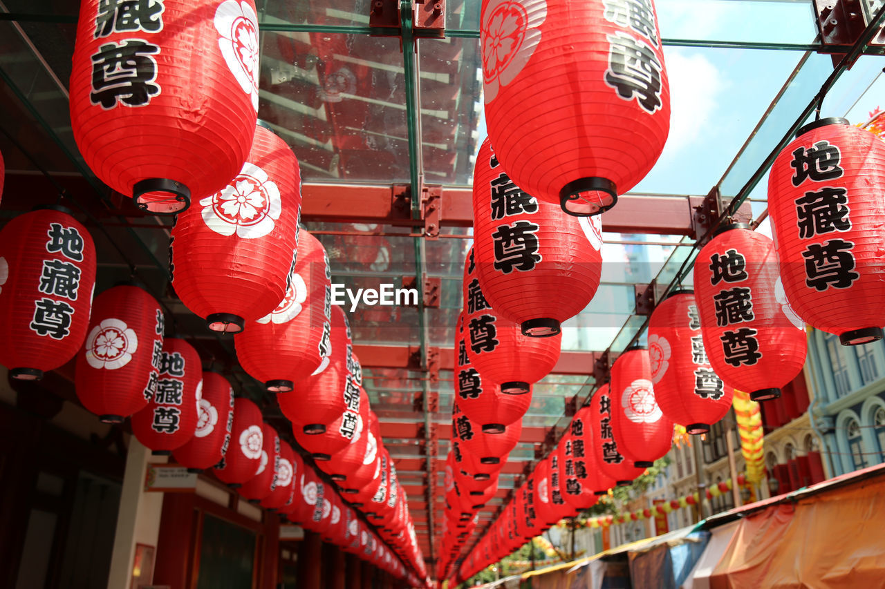 LOW ANGLE VIEW OF LANTERNS HANGING ON CEILING IN ROW