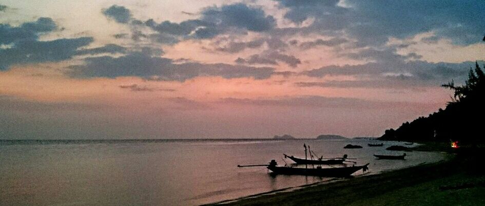 BOATS IN SEA AT SUNSET