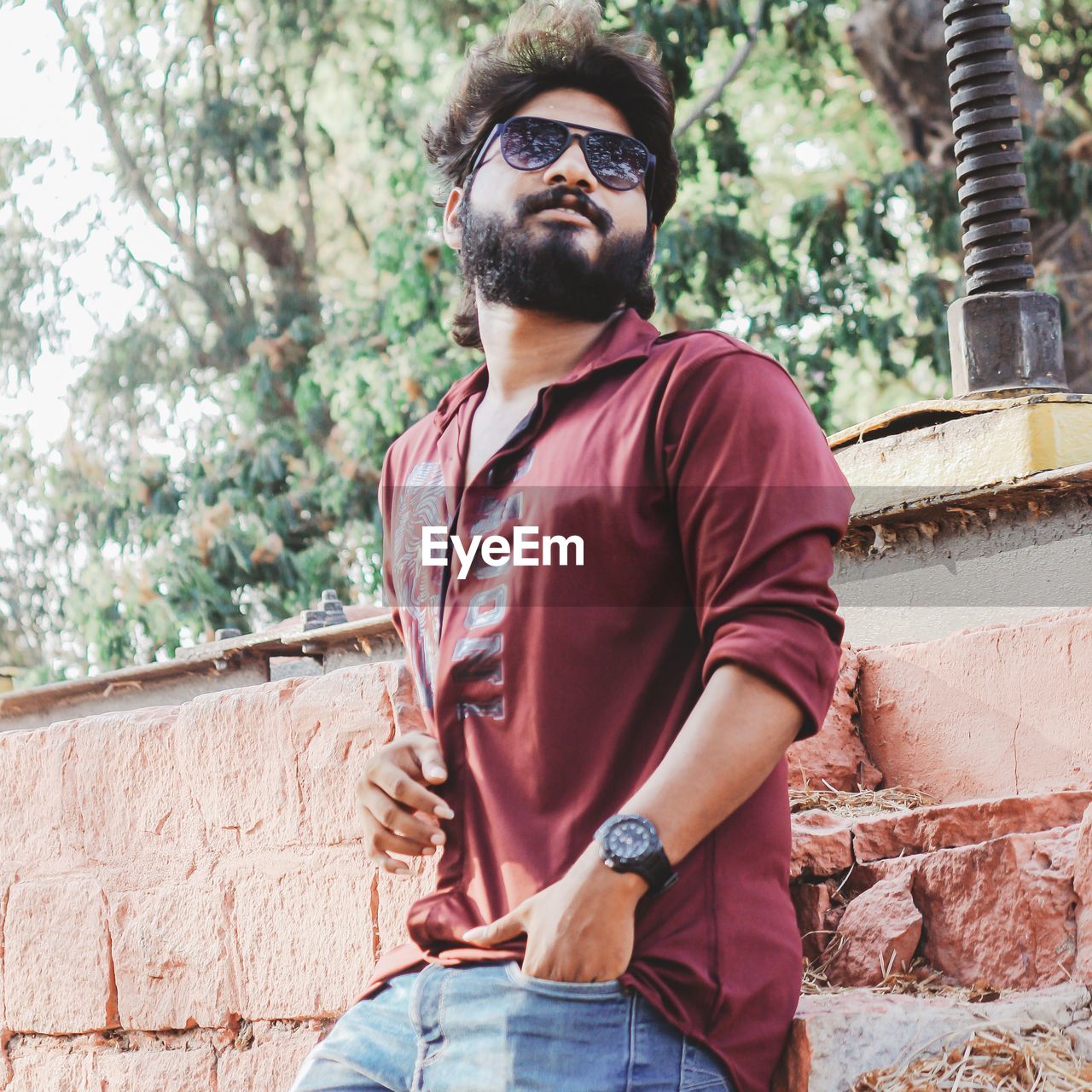 YOUNG MAN WEARING SUNGLASSES STANDING OUTDOORS