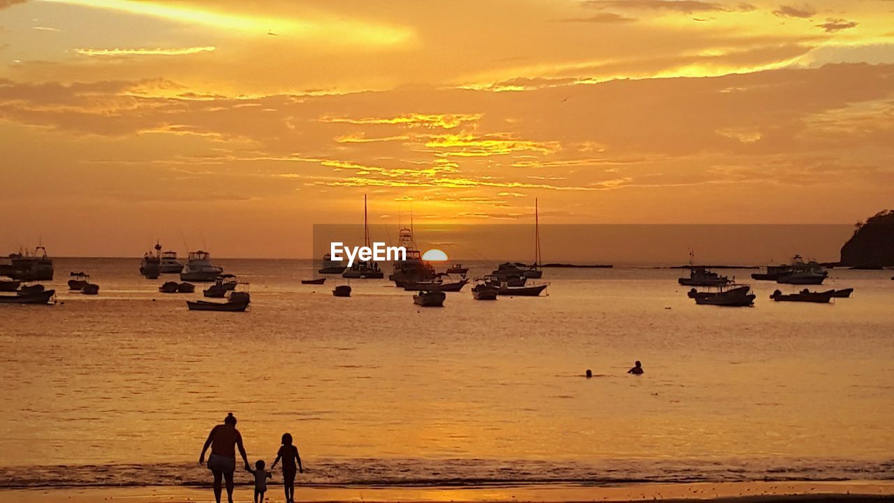 SILHOUETTE PEOPLE ON BEACH DURING SUNSET