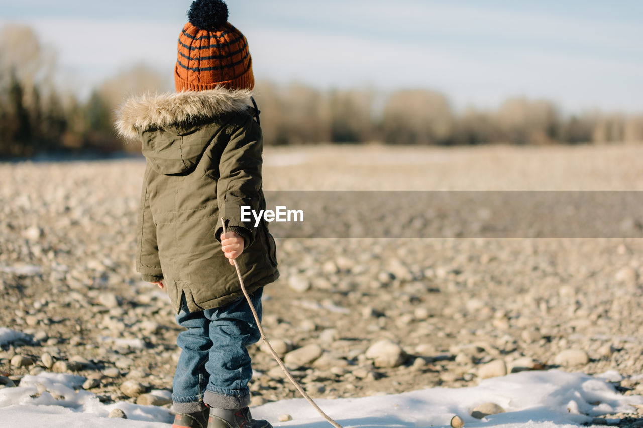 Rear view of boy standing on landscape