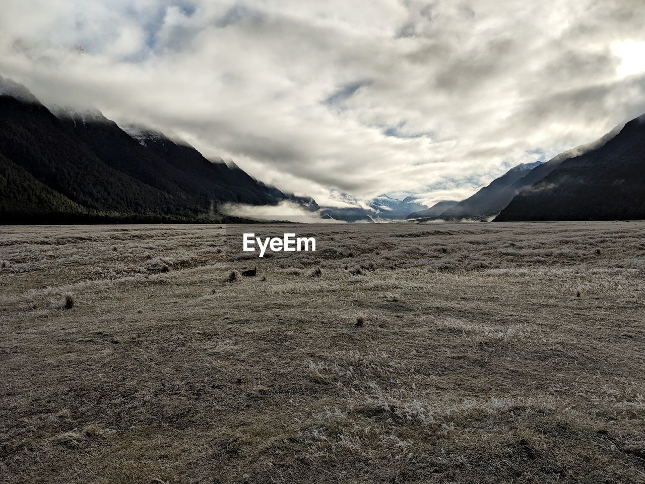 Scenic view of land and mountains against sky