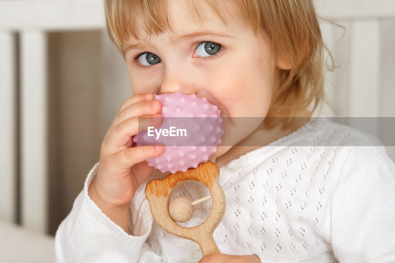 close-up of cute girl blowing bubbles in bathroom