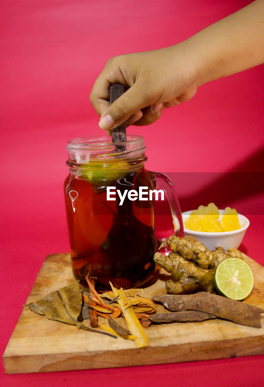 MIDSECTION OF MAN HOLDING DRINK IN GLASS