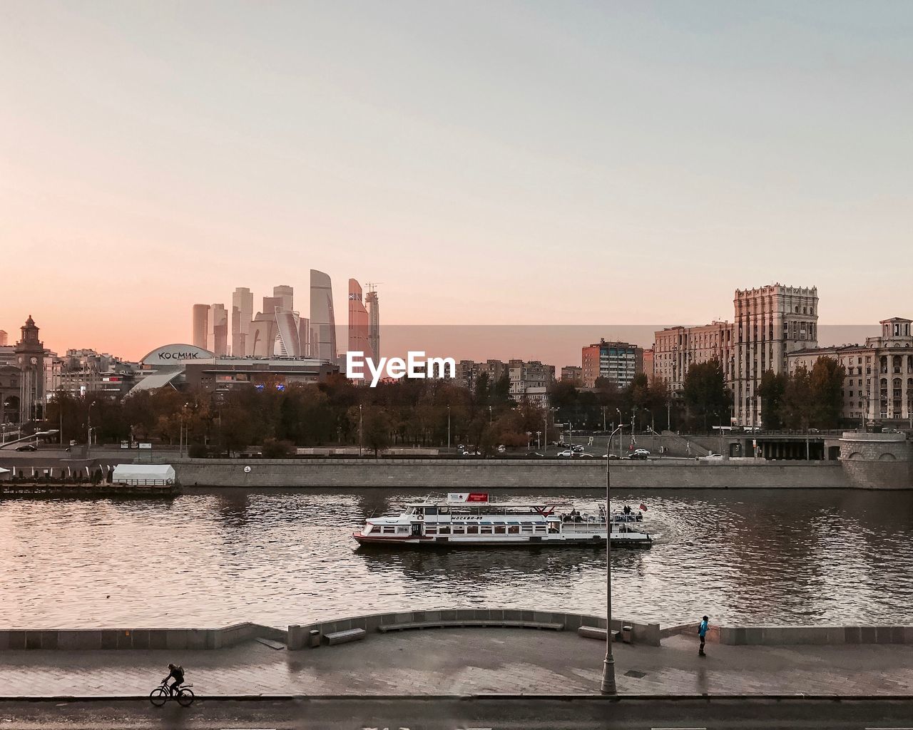 SCENIC VIEW OF RIVER BY BUILDINGS AGAINST CLEAR SKY