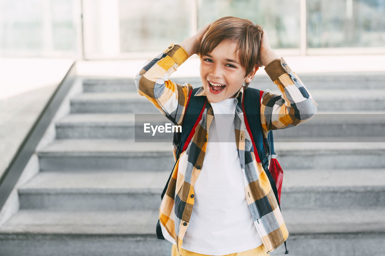 Portrait of smiling girl standing on staircase
