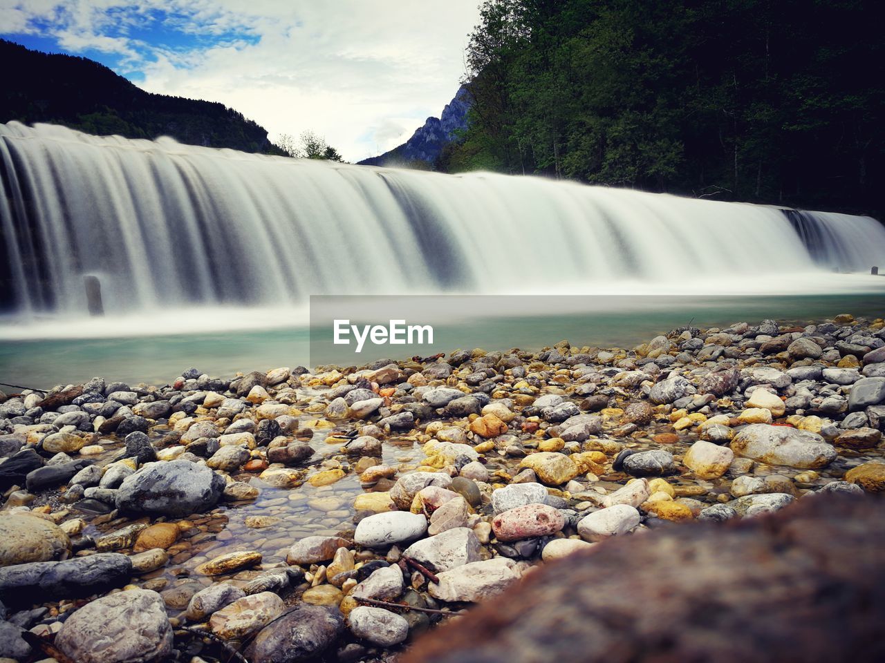 SCENIC VIEW OF WATERFALL AGAINST TREES