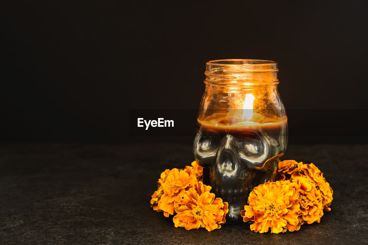 CLOSE-UP OF ORANGE FLOWER ON TABLE