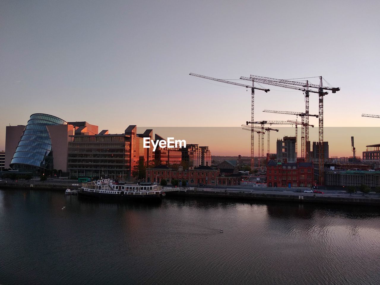 Construction in the city at sunrise and the liffey river