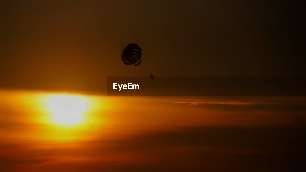 LOW ANGLE VIEW OF SILHOUETTE FLYING AGAINST SKY DURING SUNSET