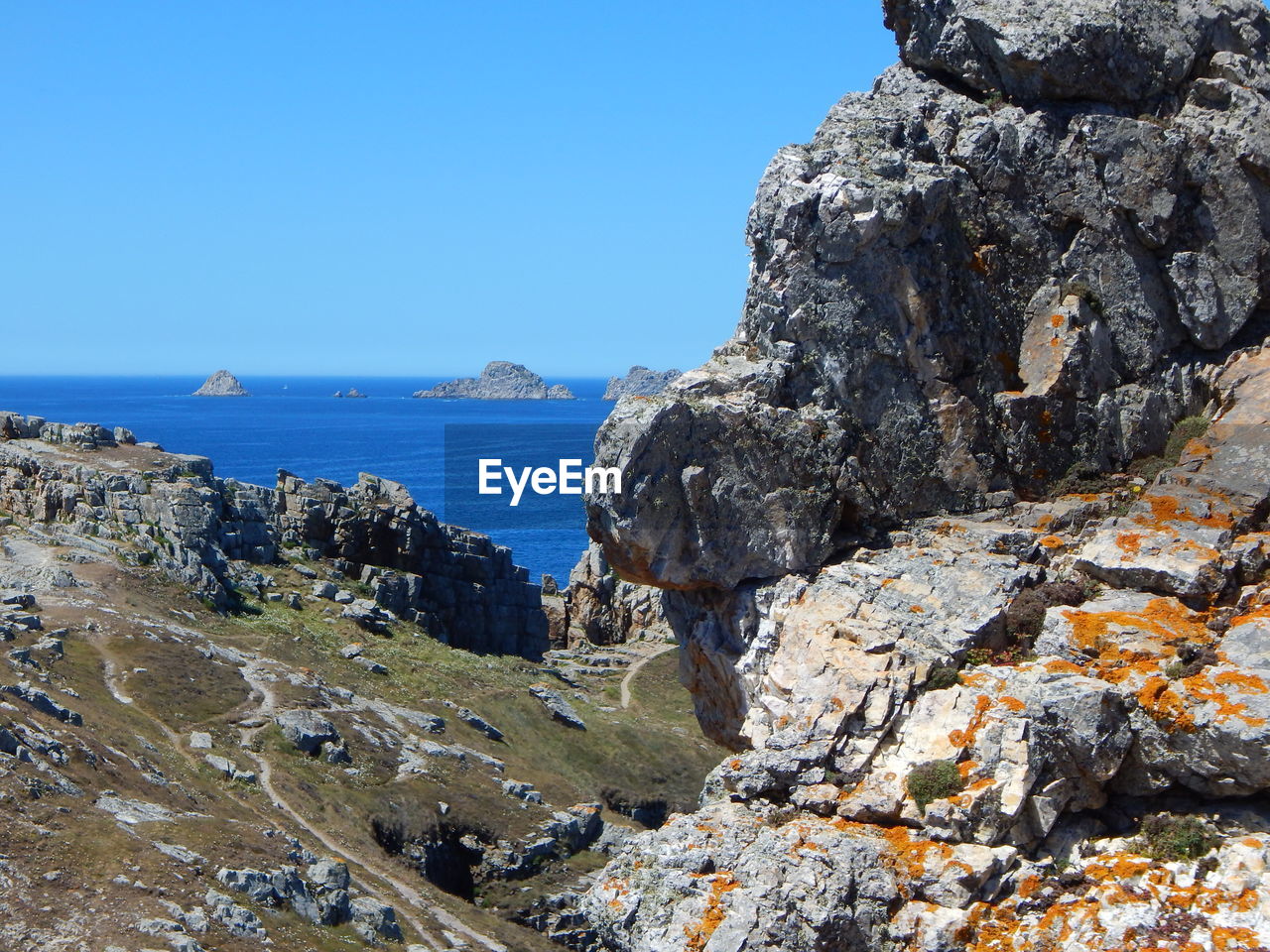 Rock formation by sea against sky