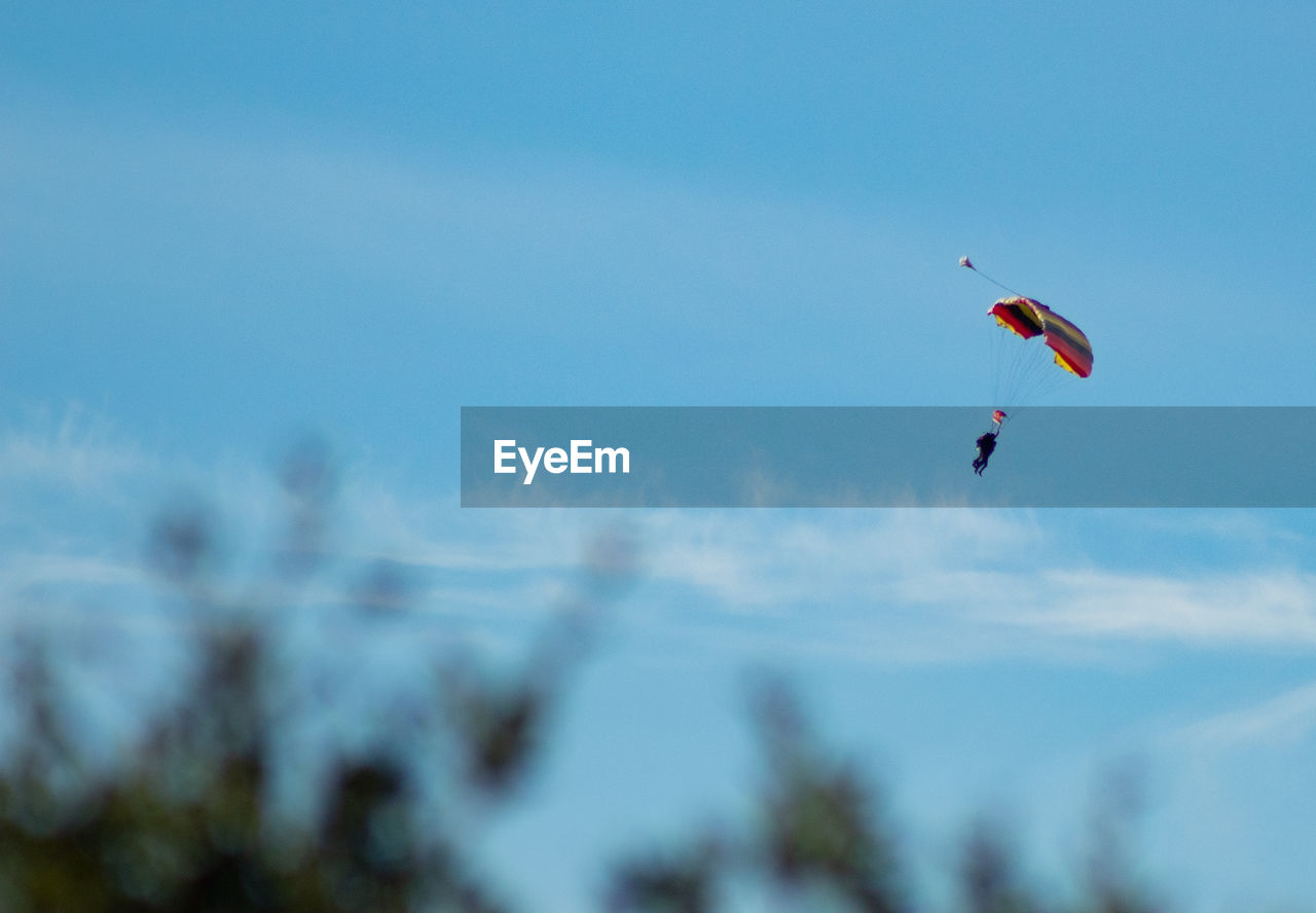 LOW ANGLE VIEW OF PERSON PARAGLIDING