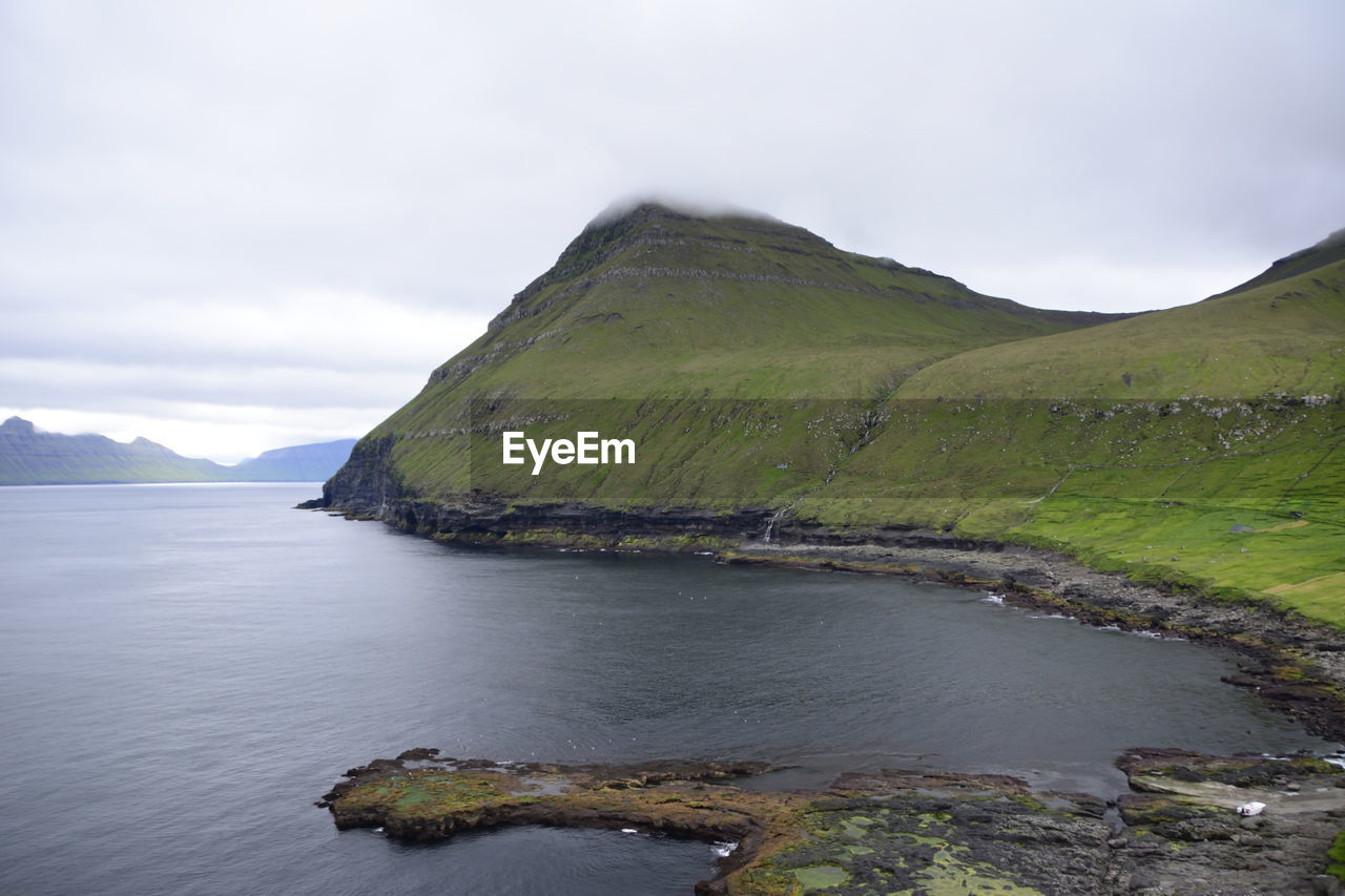 Scenic view of sea and mountains against sky