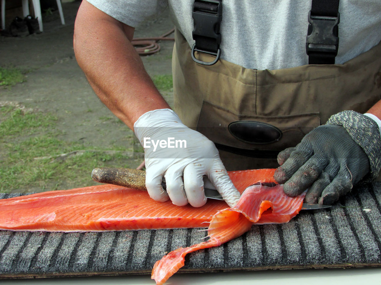 Midsection of man filleting fish at market