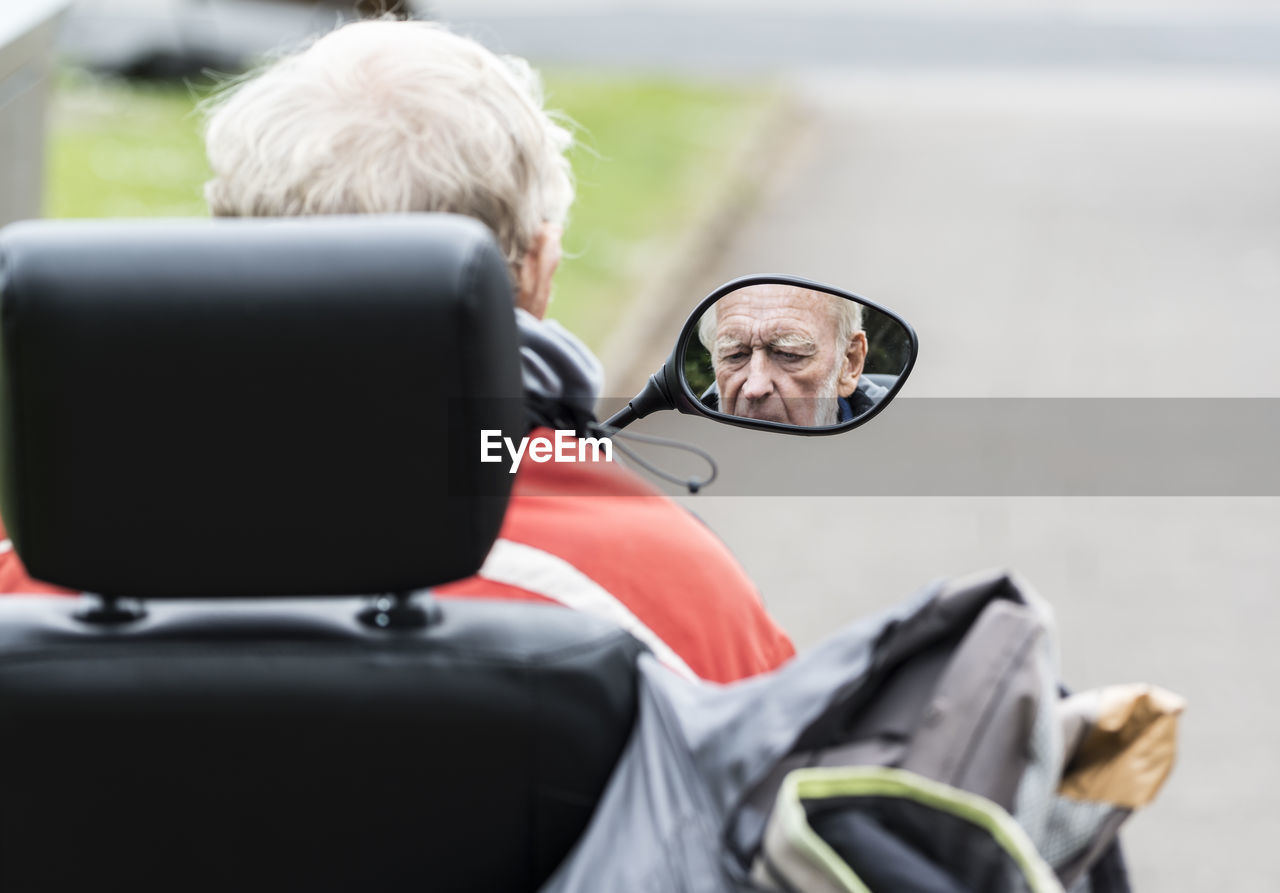 Rear view of senior man riding motorcycle