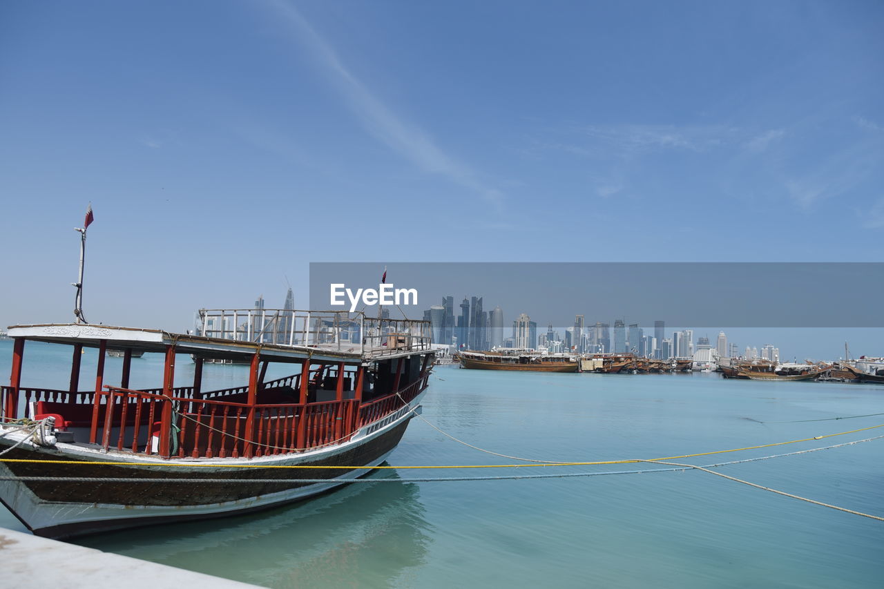 Boats moored in bay against sky