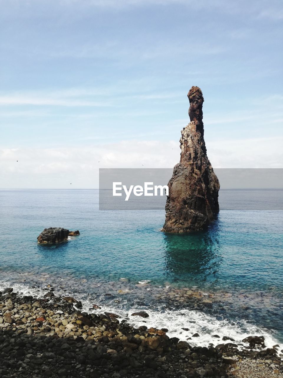 Rock formation on sea against sky