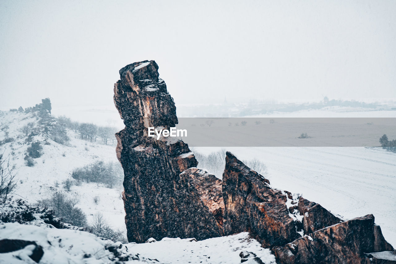 ROCK FORMATION ON SNOW COVERED LAND