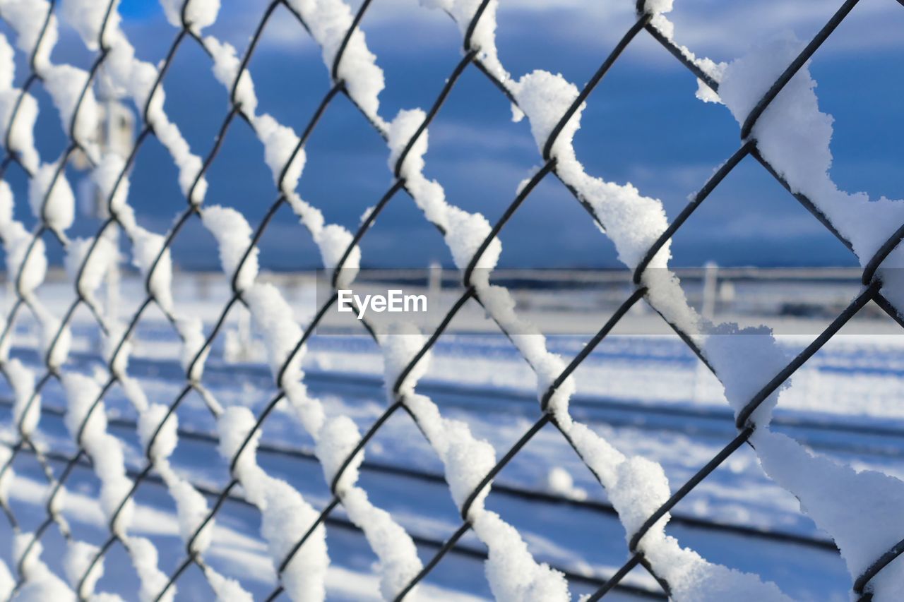 FULL FRAME SHOT OF CHAINLINK FENCE AGAINST SNOW COVERED LANDSCAPE
