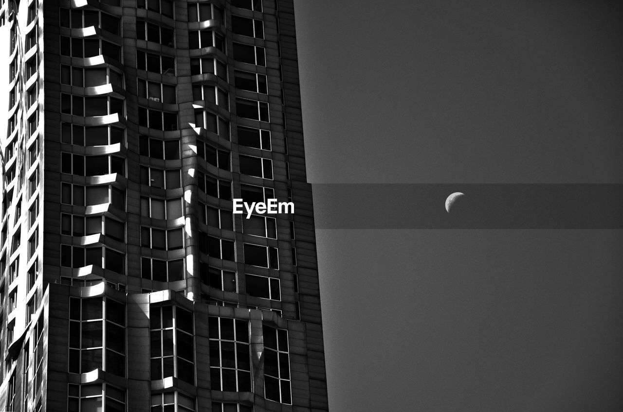 Low angle view of buildings against clear sky at night