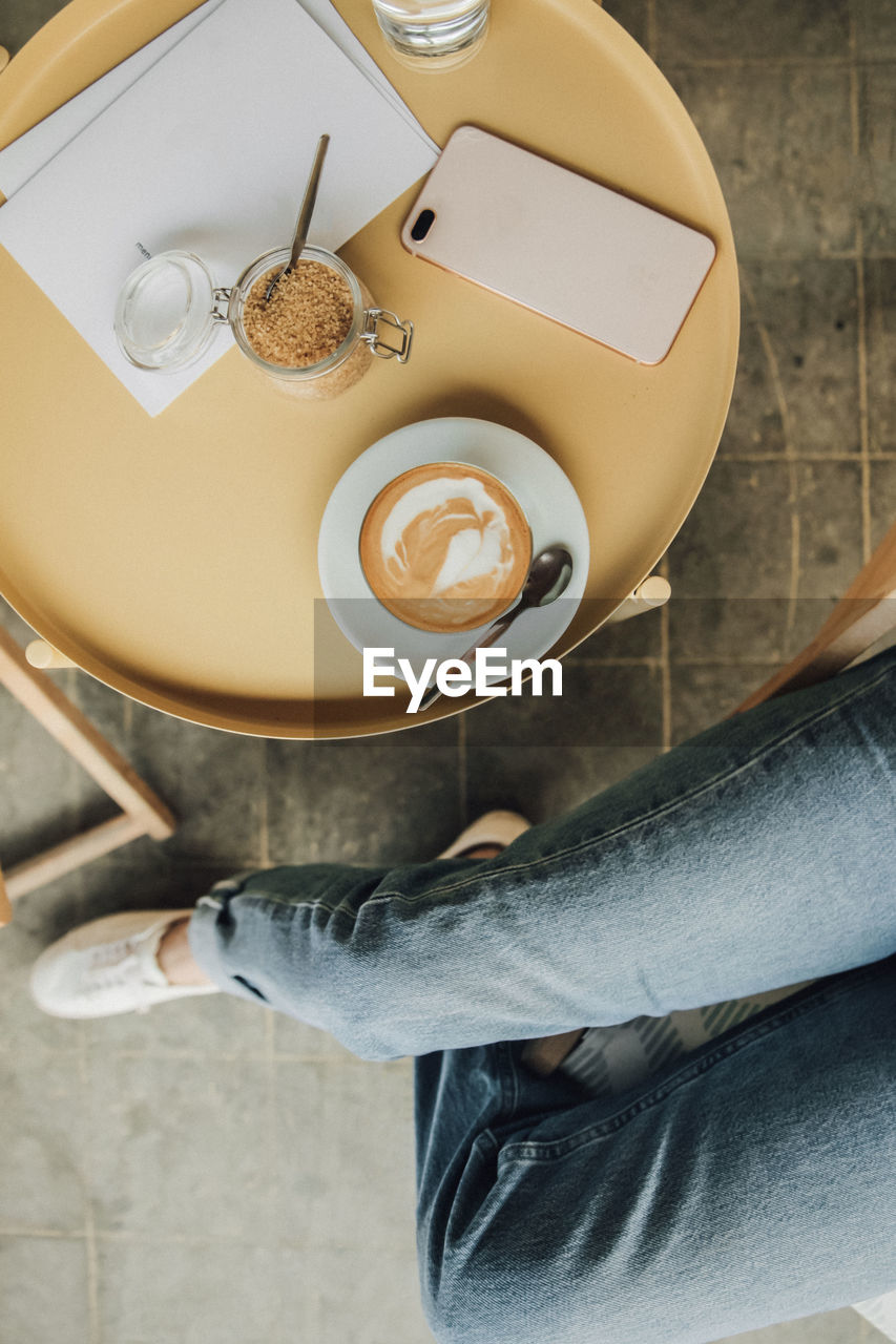 HIGH ANGLE VIEW OF COFFEE CUP WITH SPOON AND TABLE