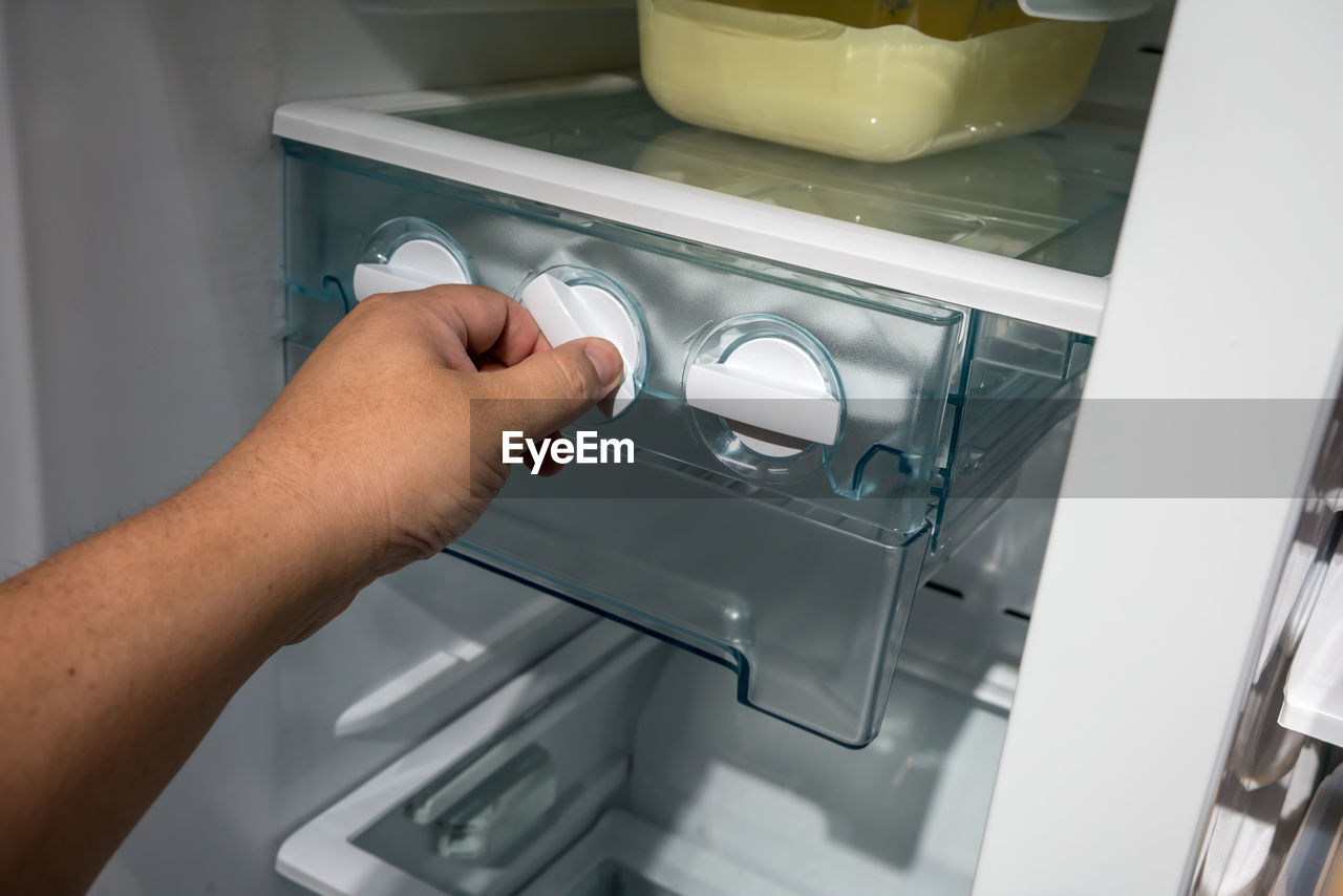 Cropped hand using refrigerator at home