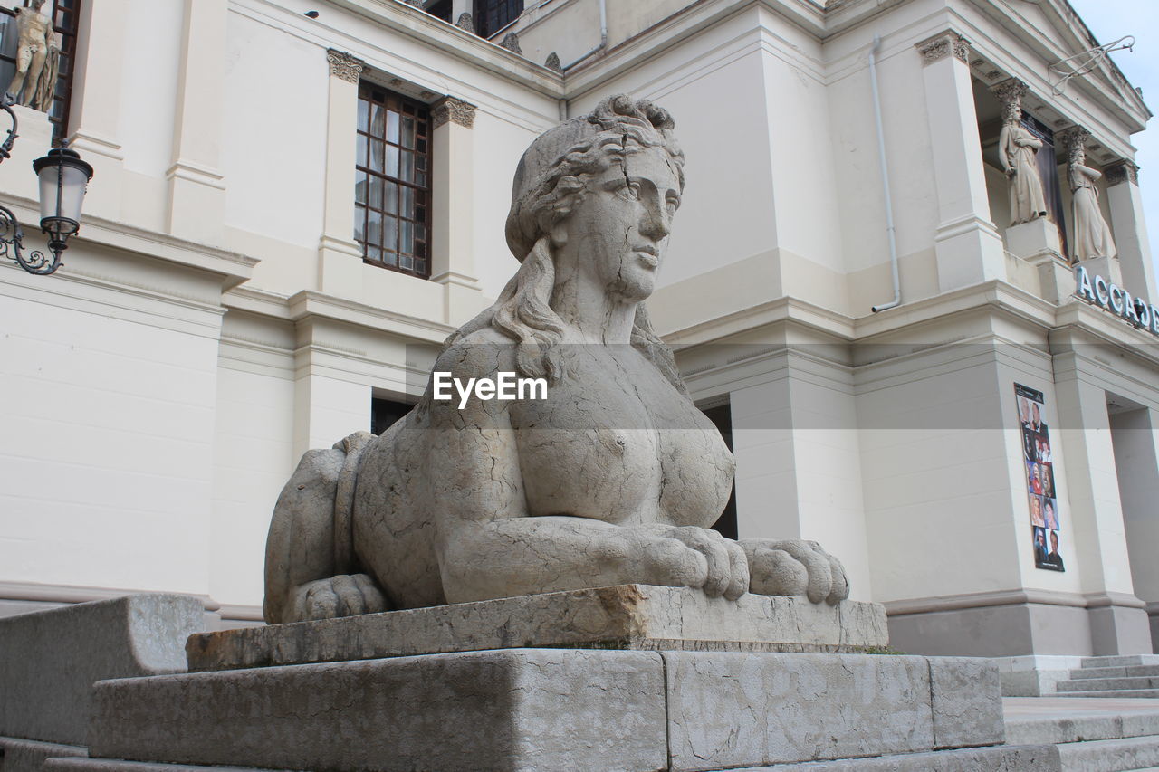 LOW ANGLE VIEW OF STATUE AND HISTORIC BUILDING