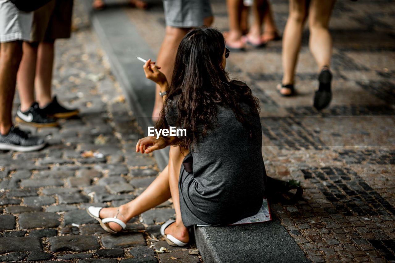 PEOPLE SITTING ON FOOTPATH