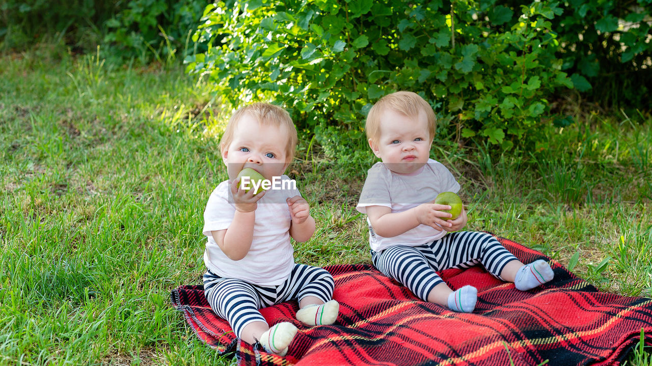 Portrait of siblings sitting on lawn