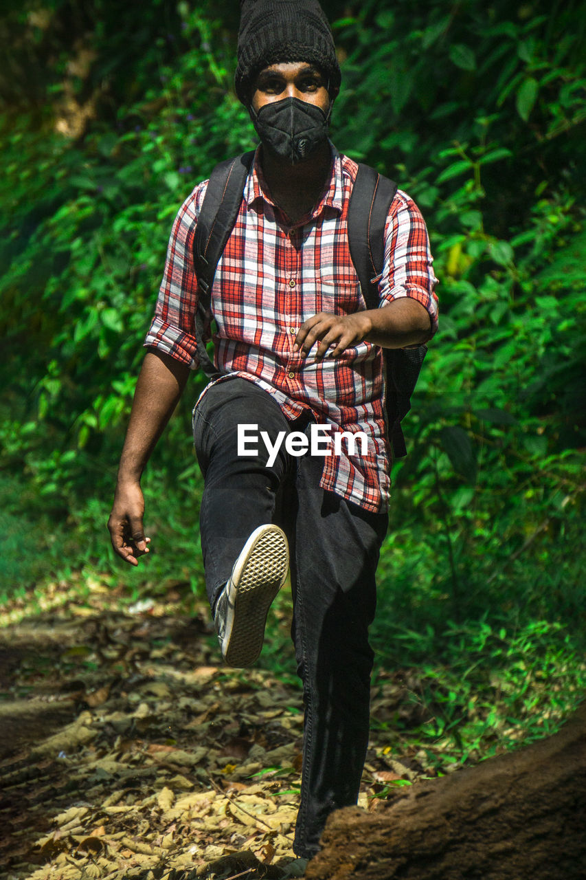 forest, one person, adult, men, tree, plant, nature, land, green, clothing, full length, outdoors, lifestyles, woodland, leisure activity, person, front view, checked pattern, jungle, footwear, activity, portrait, casual clothing, young adult
