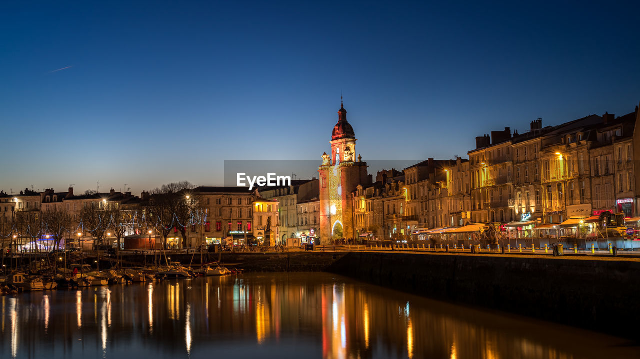 Panoramic view of the grosse horloge of la rochelle at blue hour with illuminated city light