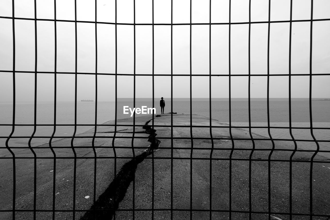 Full length of woman standing on pier against sea