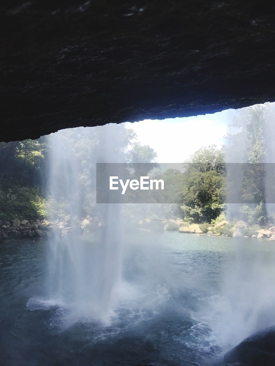 Idyllic shot of waterfall seen from cave